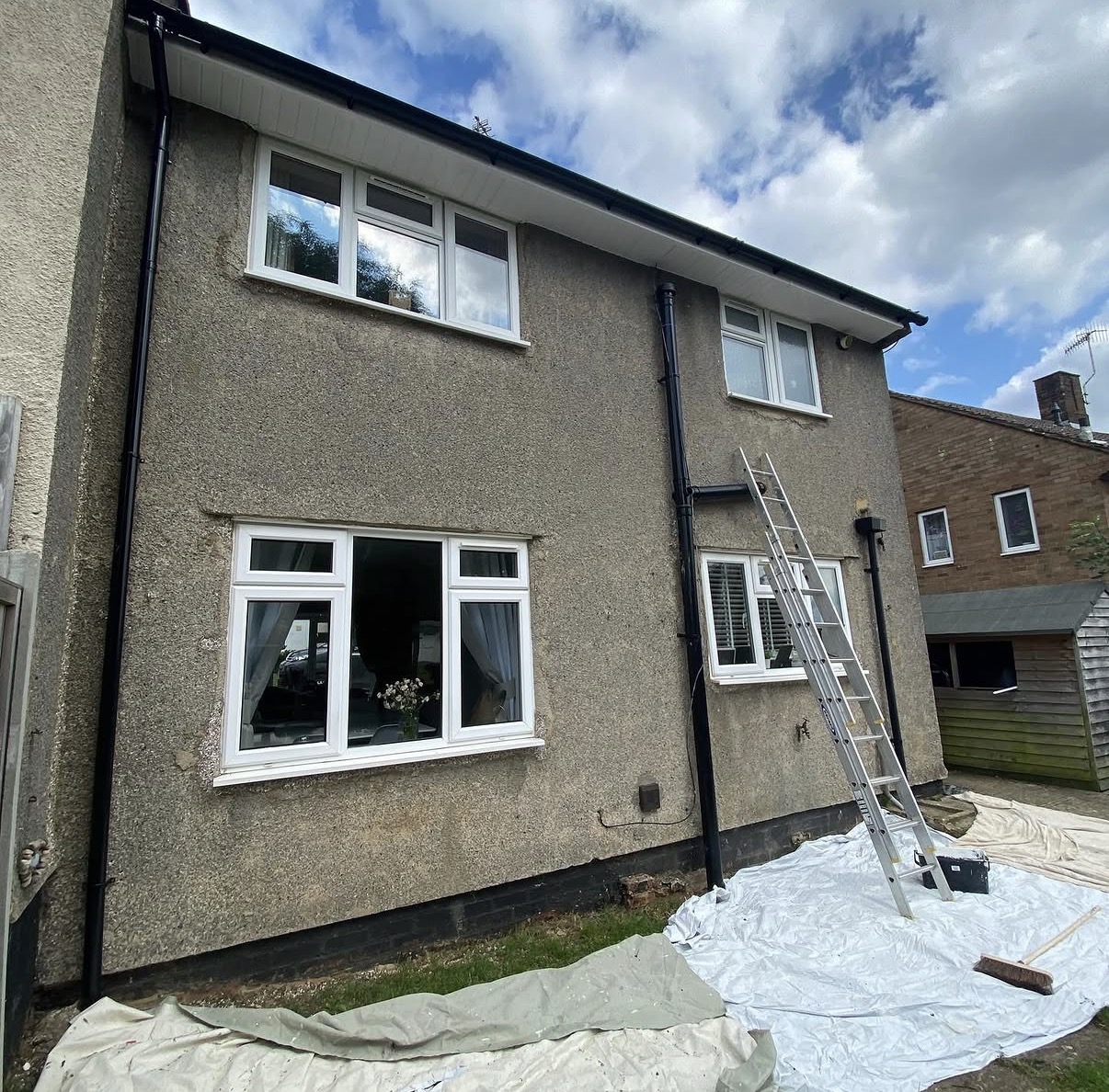 Two-story house with ladder outside.