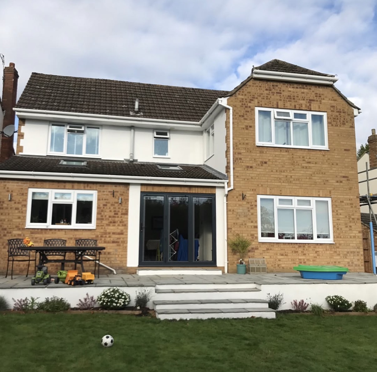 Two-story brick house with garden view.