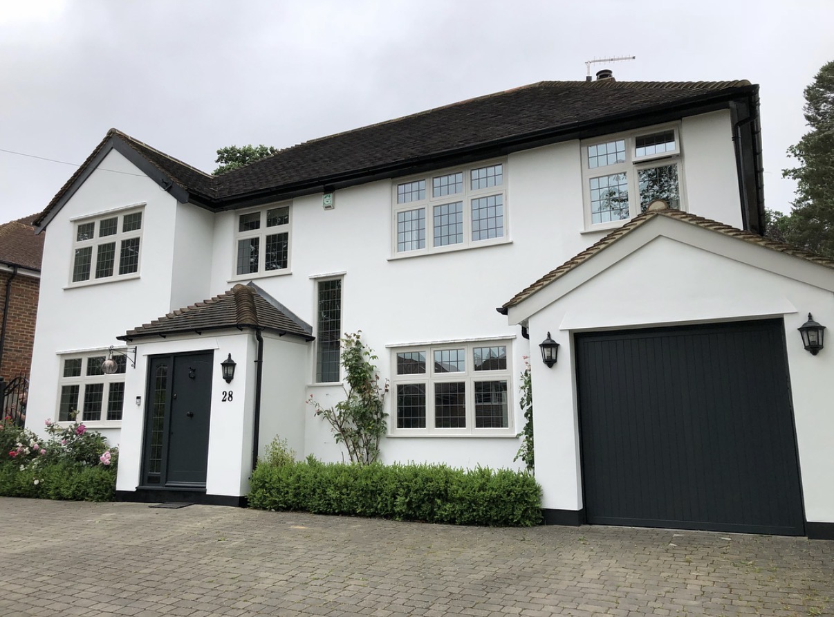 White two-story house with black garage door.